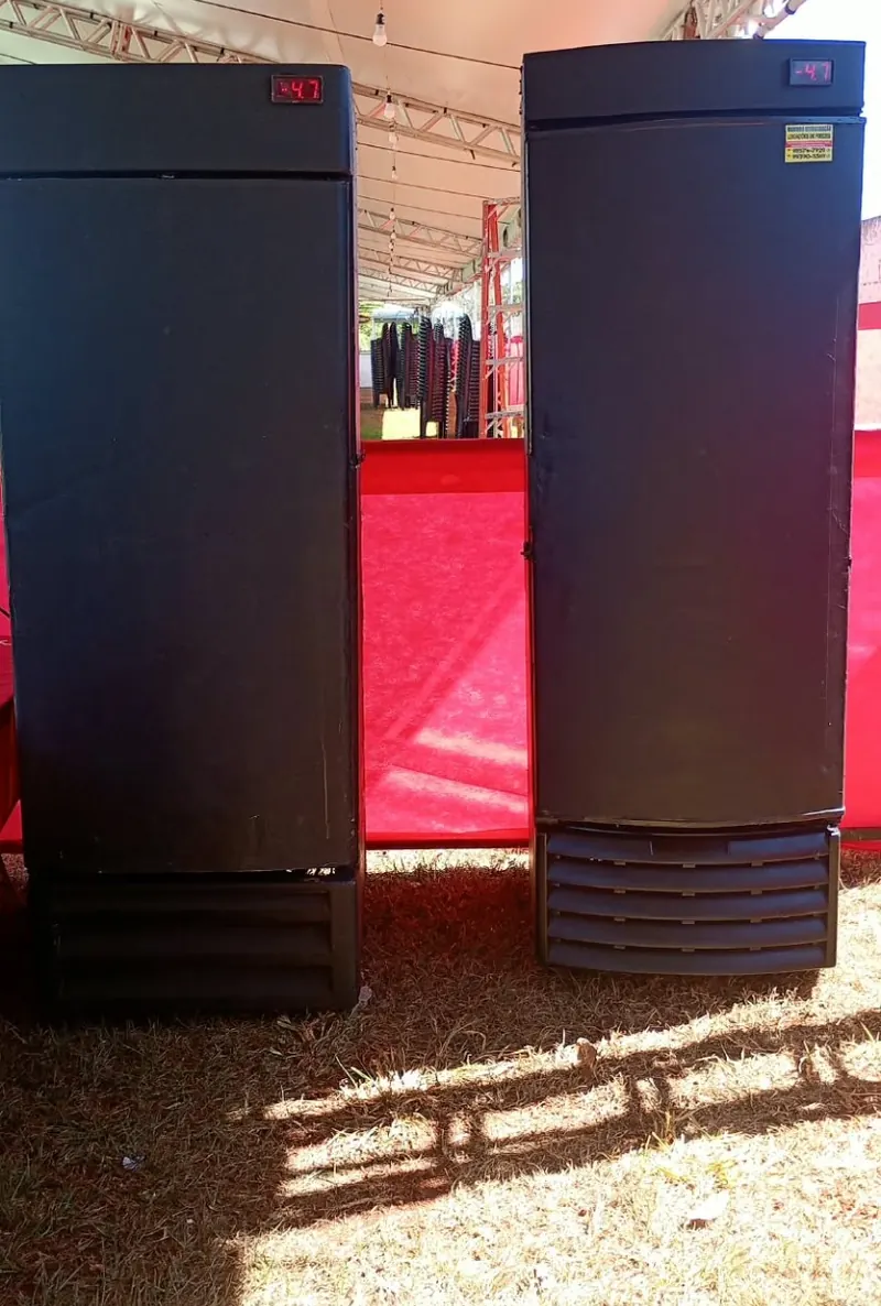 Dois equipamentos verticais pretos instalados sob uma tenda em evento